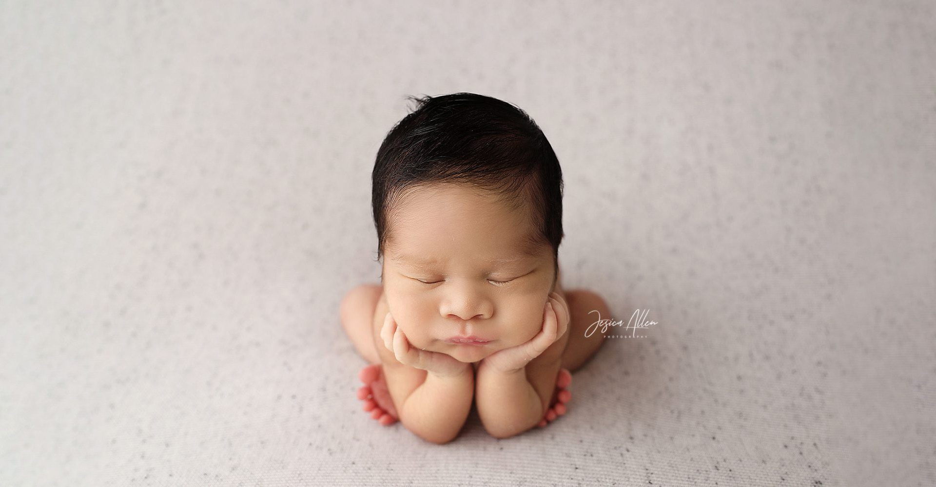 Professional photo of newborn resting her head in her hands 