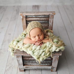A photoshoot with a newborn in a tiny wooden rocking chair 