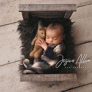 A newborn photoshoot with a baby in comfy pajamas and a stuffed animal